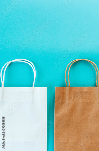 Two Kraft bags on turquoise background. Eco packaging for shopping. Season of sales and discounts