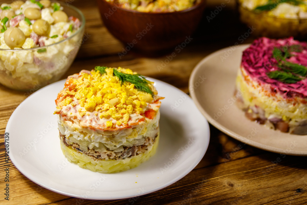 Set of festive mayonnaise salads on wooden table Set of festive mayonnaise salads on wooden table