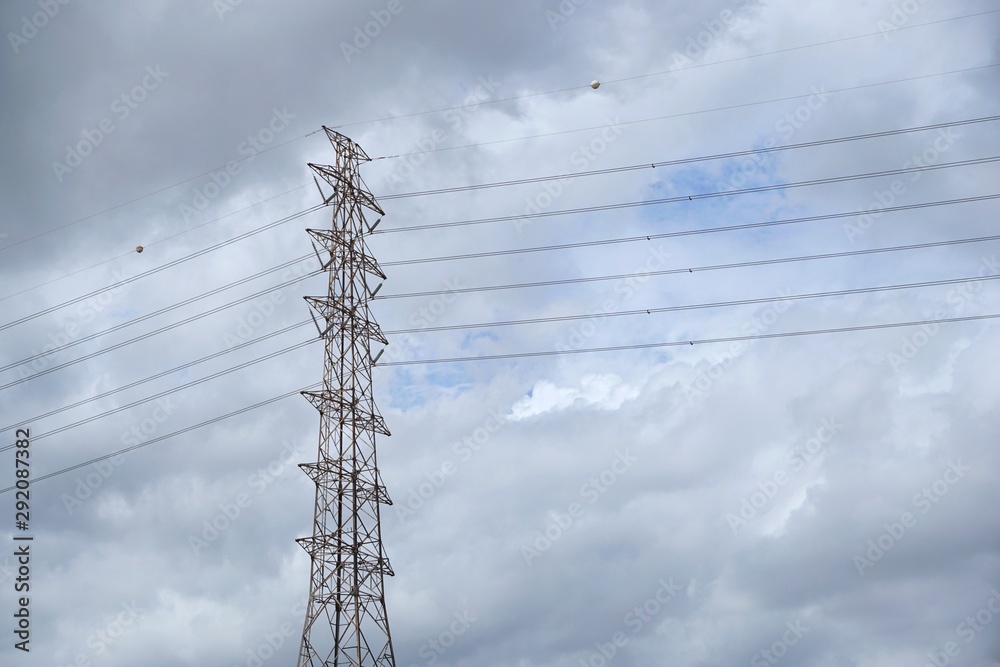 Electric tower on dramatic backdrop of sky and clounds as a background, High voltage tower in large construction site, Space for text in template Electric tower on dramatic backdrop of sky and clounds as a background, High voltage tower in large construction site, Space for text in template
