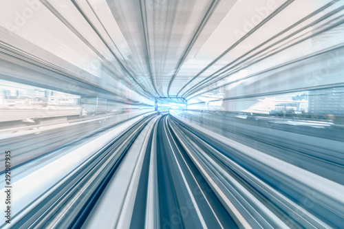 Motion blur of speed train moving in tunnel with light at end.