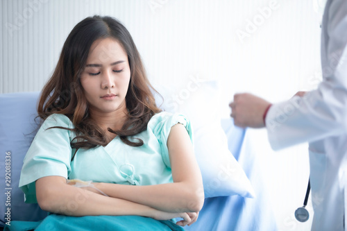 Hospitalized woman lying in bed while doctor checking examining his pulse. Doctor check feeling and talk with patient. patient thanks doctor. medical checking on bed. selective focus.