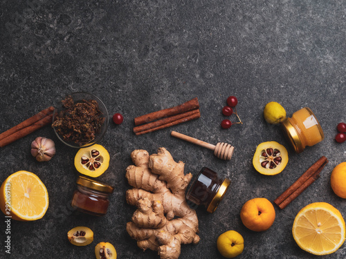 The concept of treating colds with natural resources. Honey. lemon, ginger, cinnamon, viburnum, propolis, cydonia on dark background. Alternative Medicine