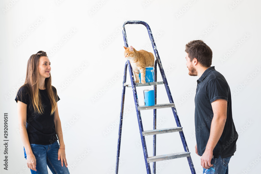 Teamwork and repair concept - young couple with cat doing a renovation in new apartment Teamwork and repair concept - young couple with cat doing a renovation in new apartment