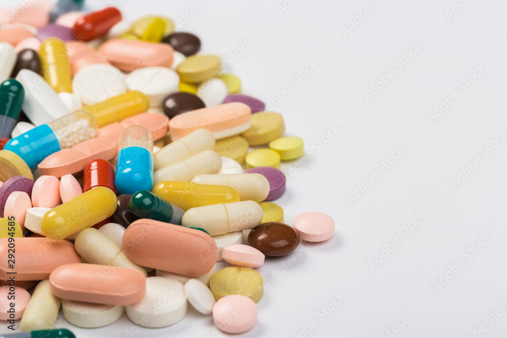 Assorted pharmaceutical medicine pills, tablets and capsules.Heap of assorted various medicine tablets and pills different colors on white background. Top view.Copy space Assorted pharmaceutical medicine pills, tablets and capsules.Heap of assorted various medicine tablets and pills different colors on white background. Top view.Copy space