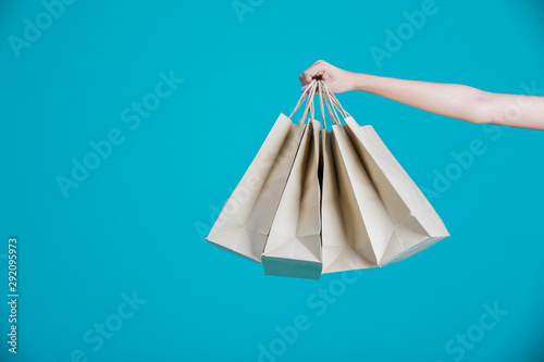 Woman holding shopping bag in blue background