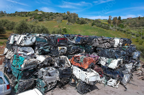 Cars in junkyard, pressed and packed for recycling.