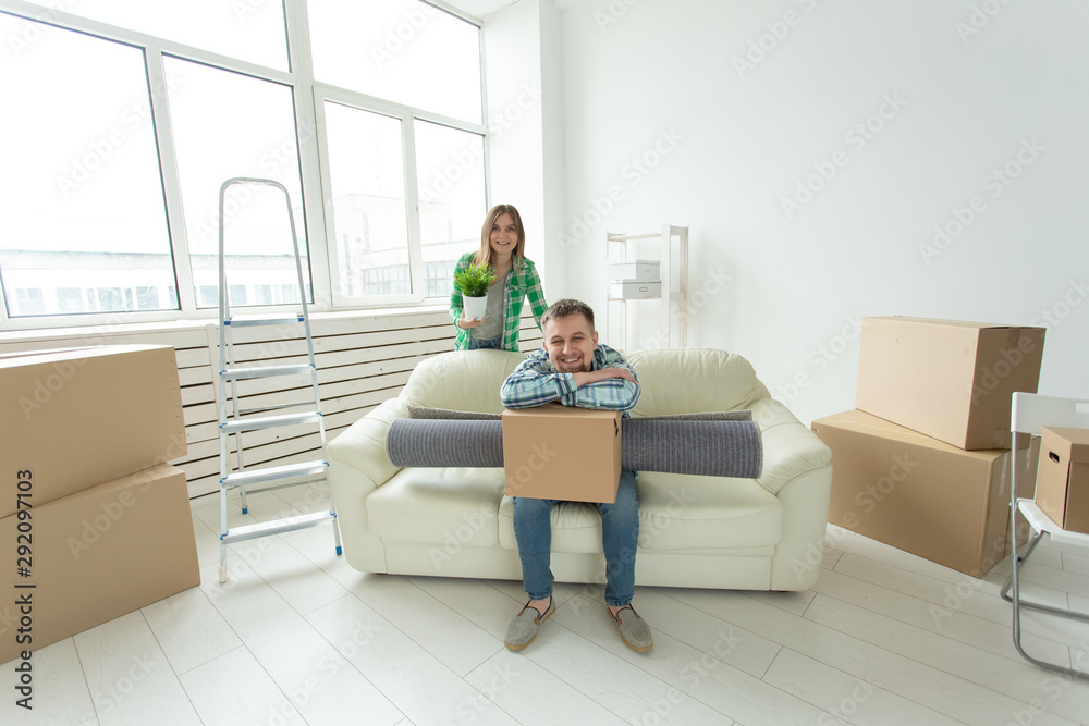 Relocation, real estate and moving concept - Young cheerful couple moving into their new home