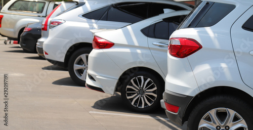 Closeup of rear side of white car with  other cars parking in outdoor parking area. © Amphon