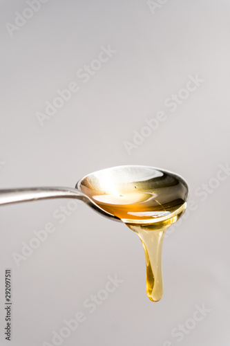 drop of honey falling from a spoon