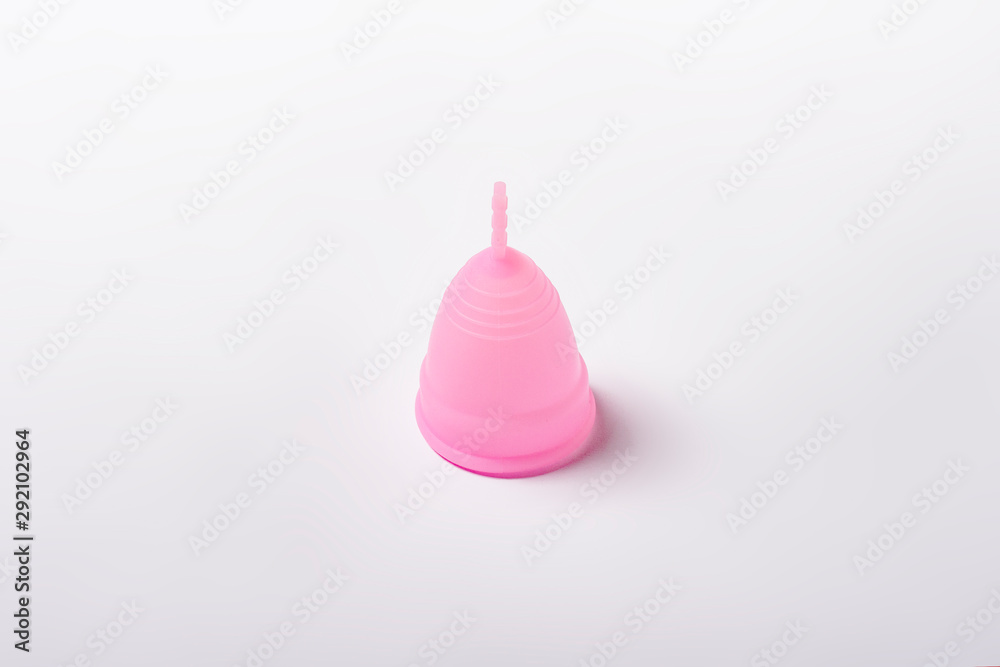 Pink menstrual cup on a white background. The concept of menstruation, the choice between feminine hygiene products. Flat lay, top Pink menstrual cup on a white background. The concept of menstruation, the choice between feminine hygiene products. Flat lay, top