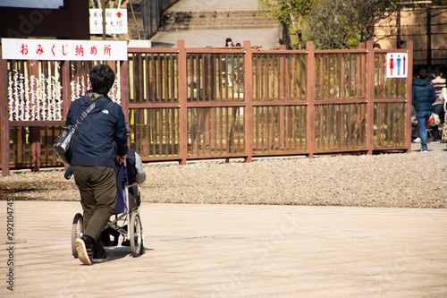 Japanese family people push wheelchair and bring oldman father walking visit and praying in Naritasan Shinshoji Temple at Chiba Prefecture in Tokyo, Japan