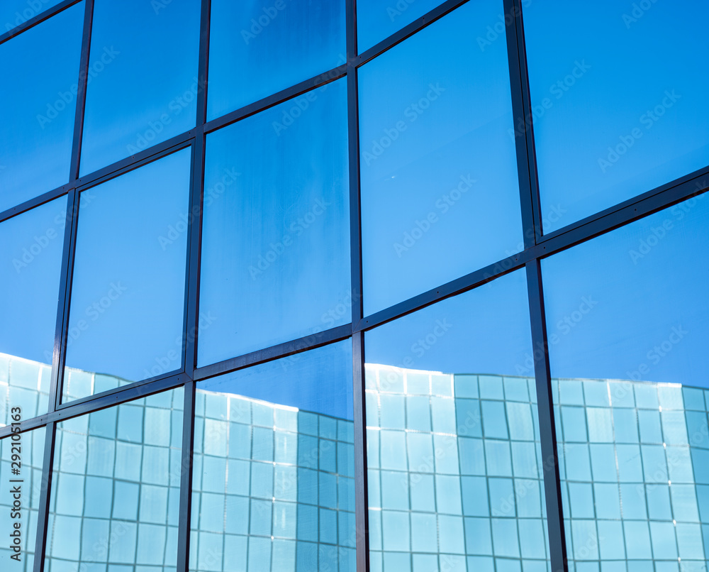 facade of modern office building in glass and steel with reflections of blue sky facade of modern office building in glass and steel with reflections of blue sky