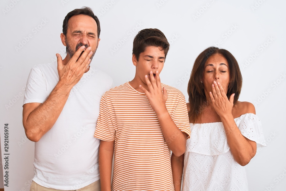 Family of three, mother, father and son standing over white isolated background bored yawning tired covering mouth with hand. Restless and sleepiness. Family of three, mother, father and son standing over white isolated background bored yawning tired covering mouth with hand. Restless and sleepiness.