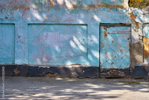 street wall and door background, aging blue facade of an abandoned fence