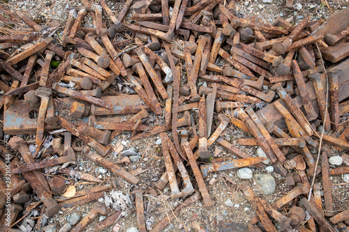 rusty railroad spikes on ground outdoors photo