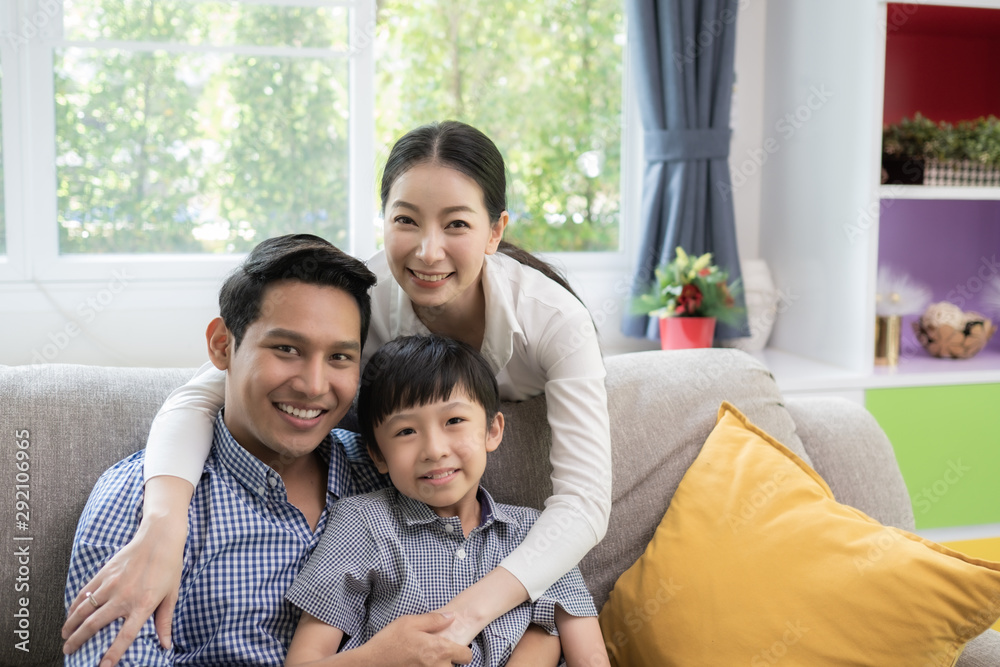 Asian family father, mother and son smiling together in living room, happy family concept Asian family father, mother and son smiling together in living room, happy family concept