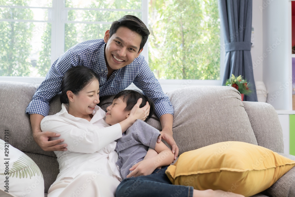 Asian family father, mother and son smiling together in living room, happy family concept Asian family father, mother and son smiling together in living room, happy family concept