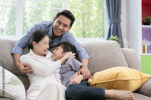 Asian family father, mother and son smiling together in living room, happy family concept