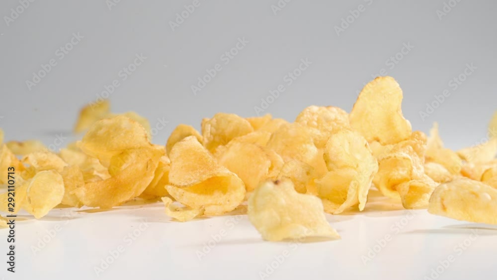 Potato Chips falling onto a white surface in slow motion Potato Chips falling onto a white surface in slow motion