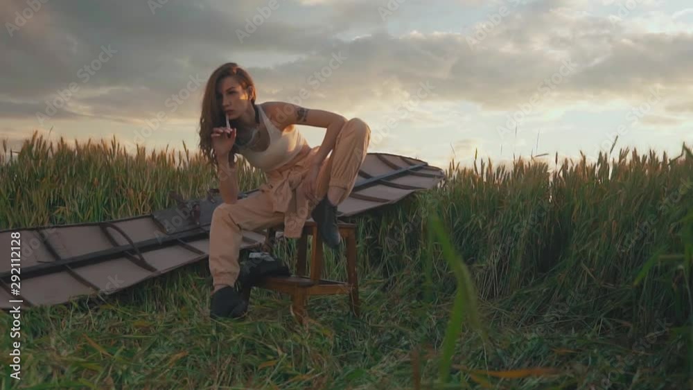 lady with long hair sits on stool against brown glider wings lady with long hair sits on stool against brown glider wings