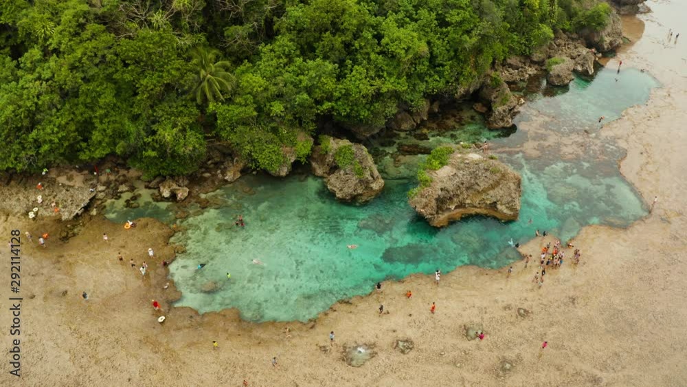 Natural pools on the rocky shore with tourists formed at low tide. Magpupungko natural rock pools. Siargao, Philippines. Natural pools on the rocky shore with tourists formed at low tide. Magpupungko natural rock pools. Siargao, Philippines.