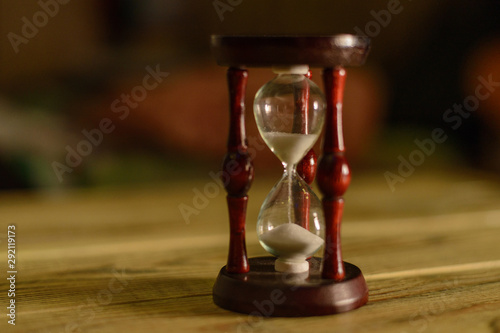 The concept of time. Hourglass on wooden background.