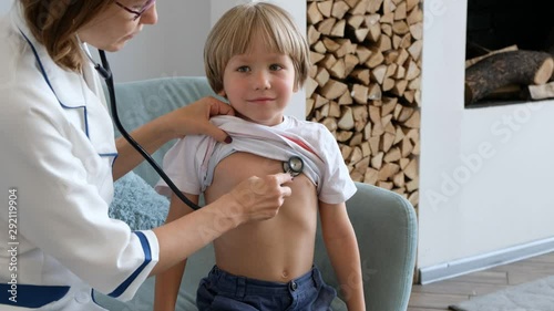 Cute boy at the doctor getting breath check up with stethoscope