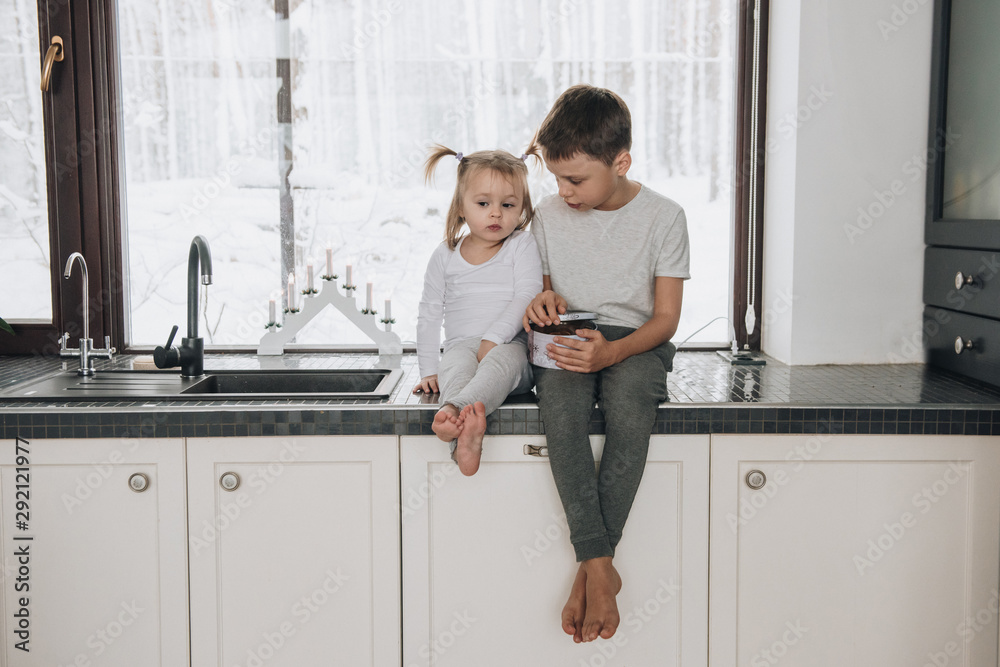 The family is sitting at the window and looking at the winter forest. Good New Year spirit. Morning in pajamas. The family is sitting at the window and looking at the winter forest. Good New Year spirit. Morning in pajamas.