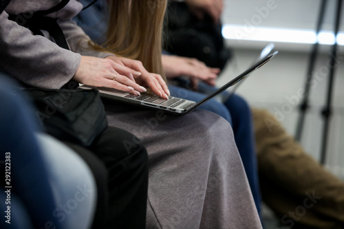 A picture of laptop. Girl holds it on her lap. She has her fingers on its keyboard. Woman types. She works © Семен Саливанчук