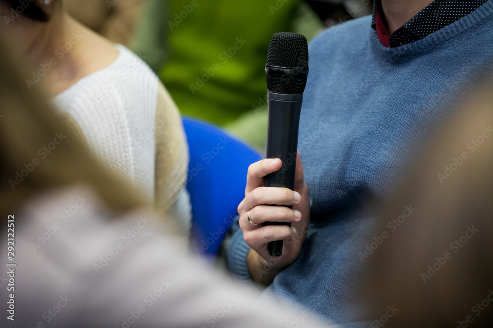 Press officer of a company giving interview to journalist with a microphone