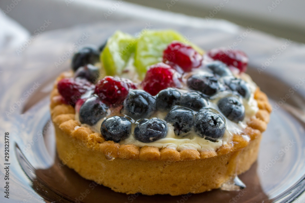 Tasty cake with fresh berries close up. Homemade tart with blueberries, raspberries and kiwi slices. Delicious dessert. Sweet breakfast concept. Pie with fruits and berries. Bakery concept. Tasty cake with fresh berries close up. Homemade tart with blueberries, raspberries and kiwi slices. Delicious dessert. Sweet breakfast concept. Pie with fruits and berries. Bakery concept.