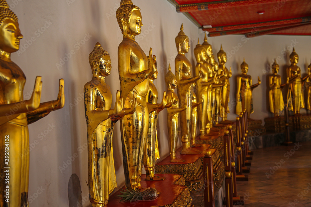 Fototapeta premium row of golden Buddha statues in Wat Pho, Bangkok, Thailand