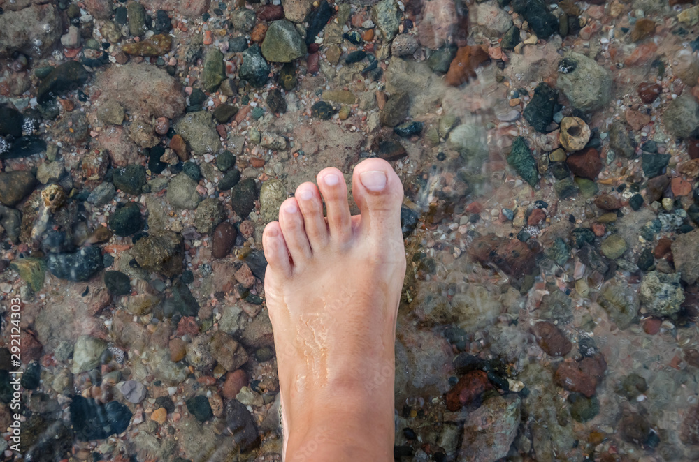 female foot on a background of sea water. female foot on a background of sea water.