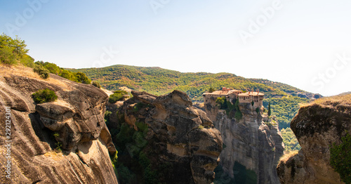 Monastery Meteora Greece. Stunning panoramic landscape. View of mountains and green forest against epic blue sky with clouds. UNESCO heritage object.