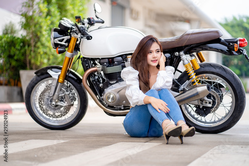 Outdoor lifestyle portrait of asian beautiful biker girl and motorcycle.