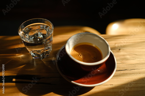 black coffee in a cup and a glass with water