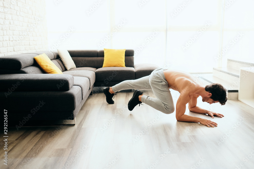 Fototapeta premium Adult Man Training ABS and Legs Doing Mountain Climbing Plank
