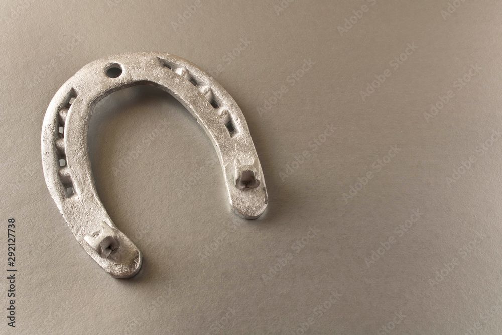Silver horseshoe on a gray background. An old horseshoe. Close up.