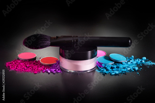 Canvas Print Makeup brushes and colorful eyeshadows on a black background