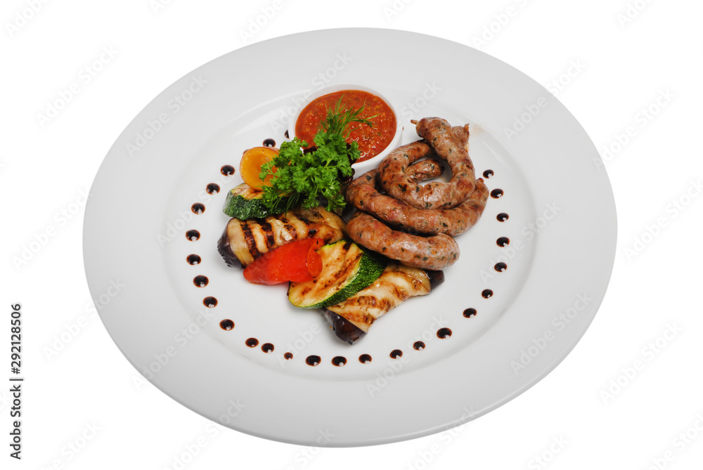 Grilled sausages with zucchini and sauce on a plate on a white isolated background