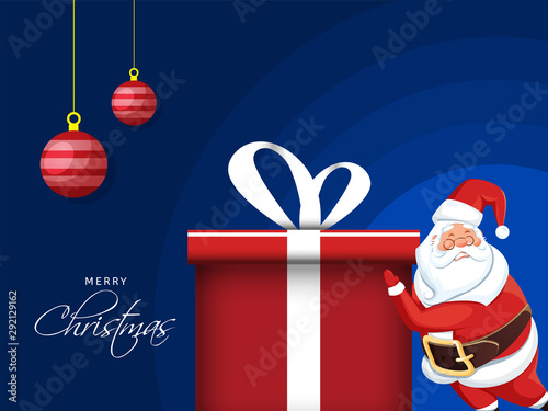 Merry Christmas celebration poster design with illustration of santa claus push a gift box and hanging baubles on blue background.