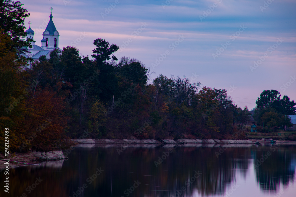 Obraz premium reflection of trees in water at sunset