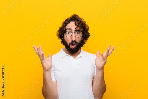 Photography young crazy man looking shocked and astonished, with jaw dropped in surprise whe