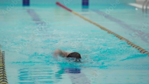 Wallpaper Mural Professional swimmer in indoor pool swimming across track. Healthy lifestyle. Sports and recreation. Torontodigital.ca