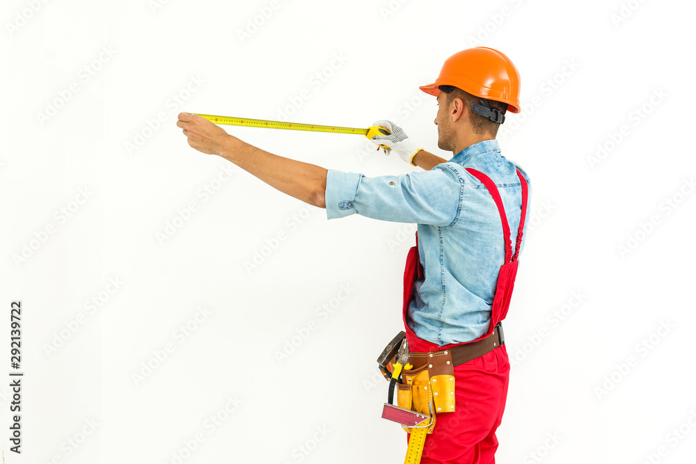 Worker in hard hat measure with ruler. Isolated on a white background. Worker in hard hat measure with ruler. Isolated on a white background.