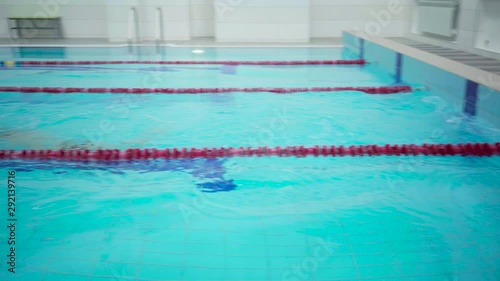 Wallpaper Mural Professional male swimmer in indoor pool swimming across track. Healthy lifestyle. Sports and recreation. Torontodigital.ca