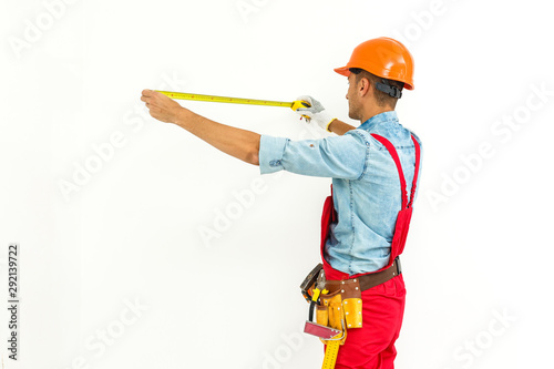 Worker in hard hat measure with ruler. Isolated on a white background. © Angelov