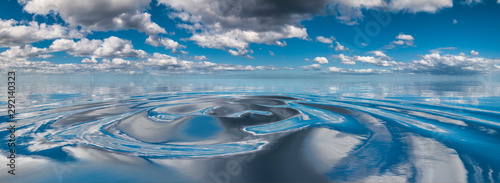 Clouds reflected in circular water ripples photo