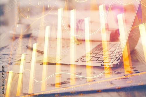 Stock market graph and table with computer background. Double exposure. Concept of financial analysis.