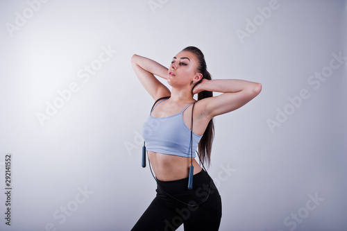 Fototapeta Naklejka Na Ścianę i Meble -  Cheerful attractive young fitness woman in top and black leggings with jump rope isolated over white background.